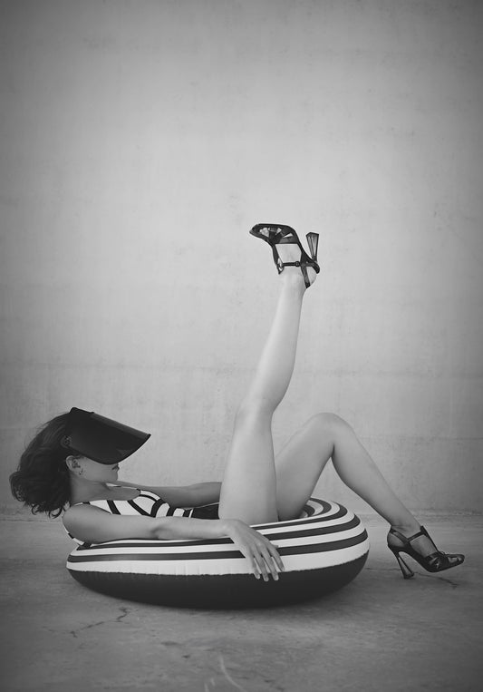 Photographie contemporaine de Vanessa Moselle – femme allongée sur bouée rayée en talons hauts