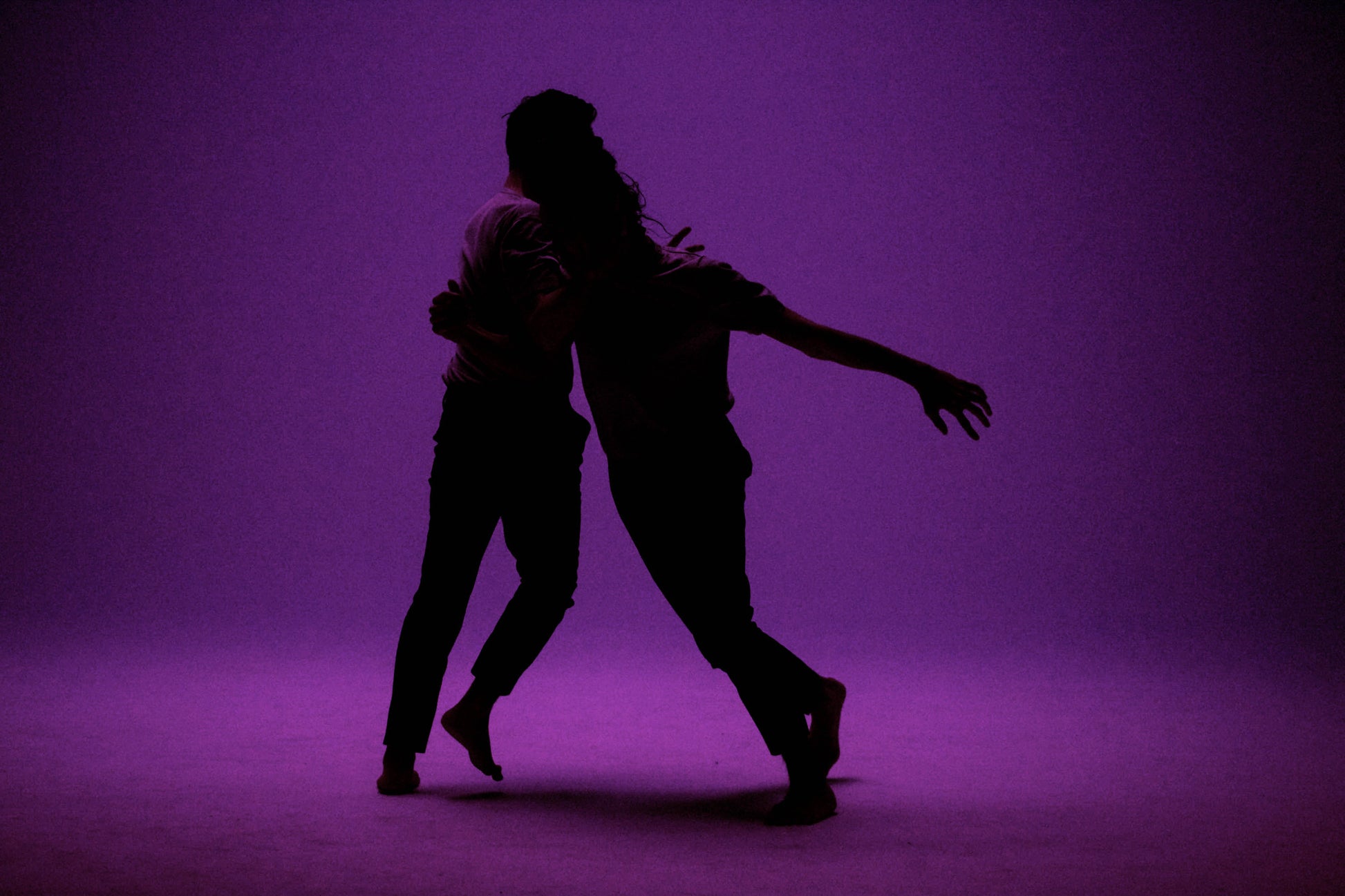 Photo de deux danseurs en mouvements qui s’enlacent. La photo est faite en studio et est de couleur violette. Les danseurs sont dans l’ombre nous ne distinguons que leurs silhouettes. Photo prise par l’artiste Alice Sevilla à Paris en France.